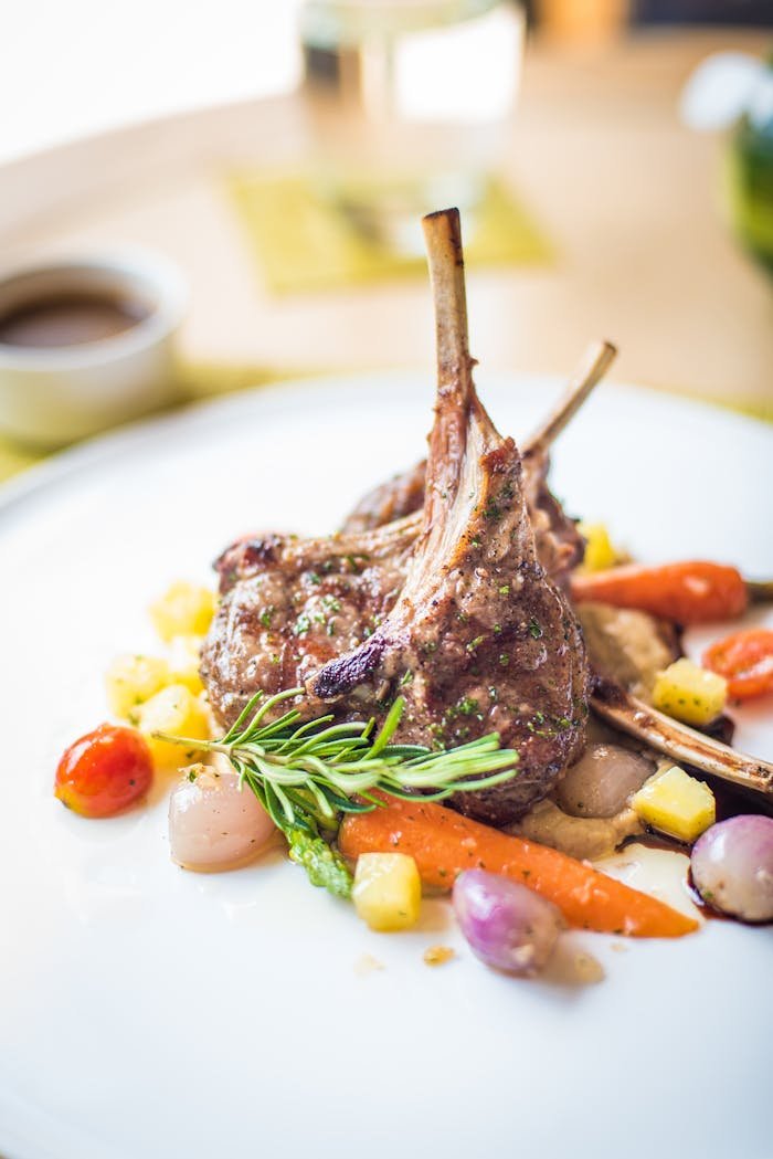 Home Exquisite plated lamb chops with colorful vegetables, showcasing fine gastronomy.