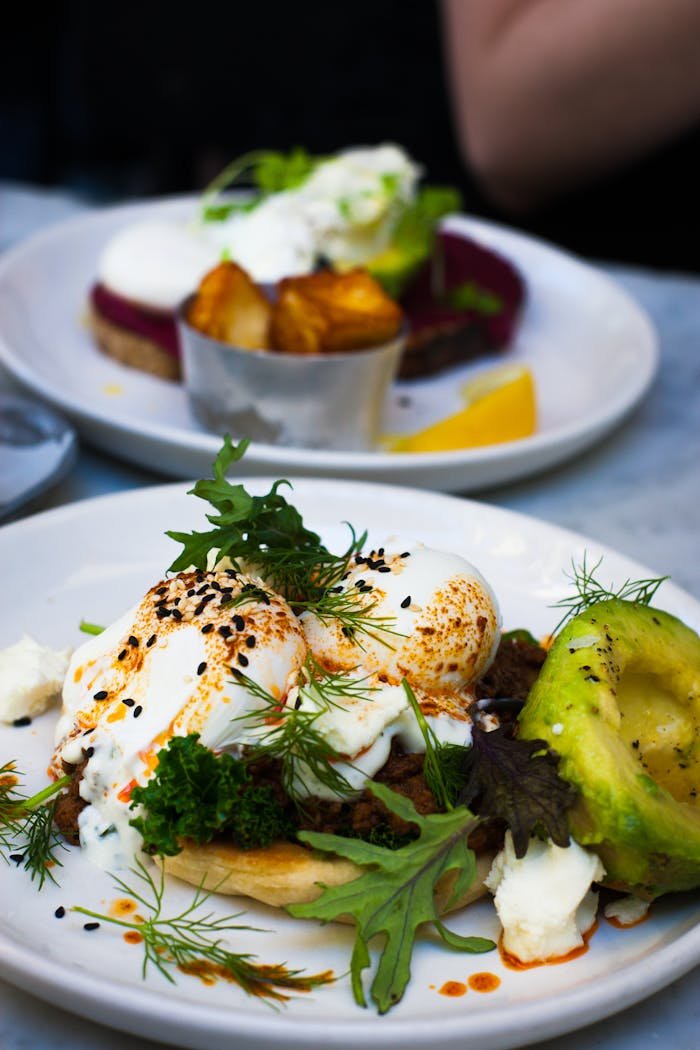 Home Delicious poached eggs served with avocado and fresh greens, perfect for a healthy gourmet brunch.